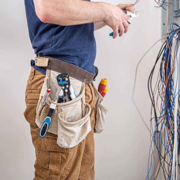 constructor-electricista-trabajo-examina-conexion-cable-linea-electrica-fuselaje-cuadro-distribucion-industrial-profesional-monos-herramienta-electricista_169016-8635